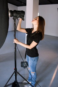 Photographer adjusting studio lighting equipment