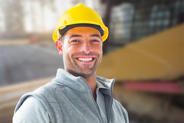 Smiling young man in a yellow hard hat