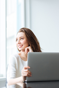 Woman smiling working on a laptop