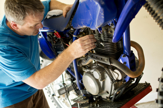 Mechanic working on a motorcycle engine in a workshop