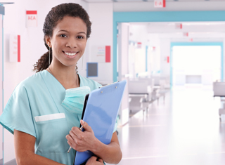 Nurse in teal scrubs holding a clipboard in a hospital corridor