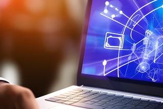 Person using a laptop displaying abstract science and technology graphics