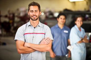 Three auto mechanics in a workshop.