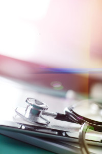 Close-up of a stethoscope on a reflective surface with a colorful background