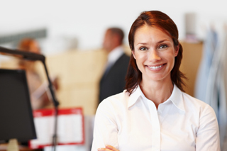 Woman with brown hair wearing white shirt in office environment