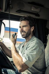 male truck driver in grey shirt inside truck