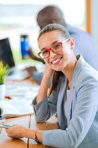 Woman with glasses sitting at desk in office environment