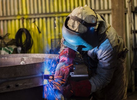 Student learning welding skills in a training workshop.