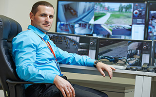 Security professional monitoring CCTV footage in a surveillance room