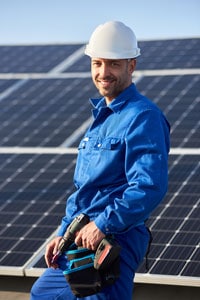 electrician working on solar panels on roof