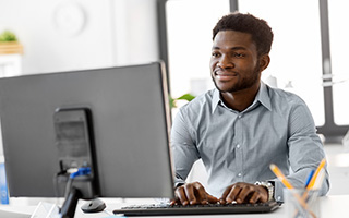 young African American man working on a desktop computer