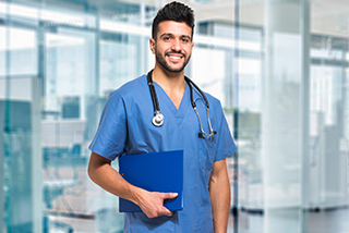 Nurse in blue scrubs holding a clipboard in a modern hospital setting