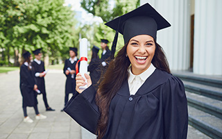 happy female college graduate in cap and gown