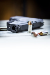 Handgun with ammunition on a table, close-up focus on barrel