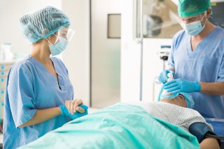 anesthesiologist administering anesthetic to surgical patient