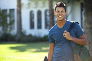 Smiling young man with backpack on a university campus