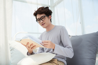 Happy man on a couch reading a book