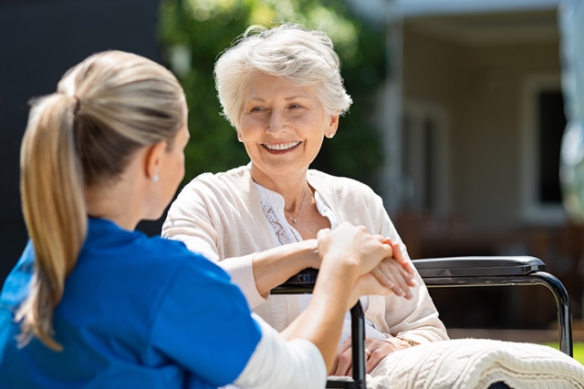 leende senior sitter med en sjuksköterska