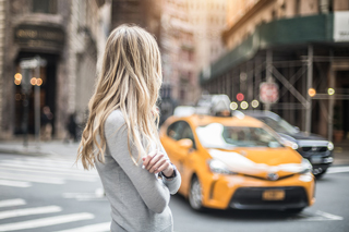 Woman on the sidewalk waiting for a taxi