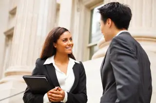 Two legal professionals chatting outside a courthouse