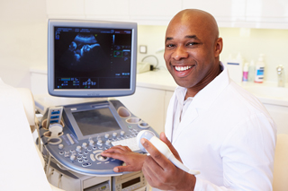 Ultrasound technician in a lab coat operating an ultrasound machine in a medical clinic