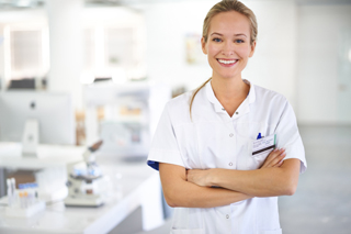 Medical lab tech in white lab coat standing with arms crossed in dental clinic.