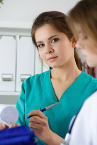 Two medical office administration professionals discussing over a document in a clinic