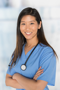 Nurse in blue scrubs with stethoscope standing confidently