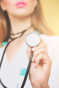Doctor holding a stethoscope towards the camera, partial close-up, vibrant yellow background