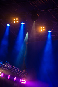 Concert stage with bright lights and smoke effects under a dark tent