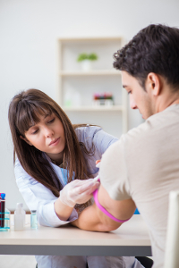 Nurse bandaging the arm of a patient in a medical office.