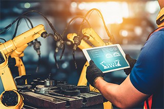 Technician working with industrial robotics and automation equipment.