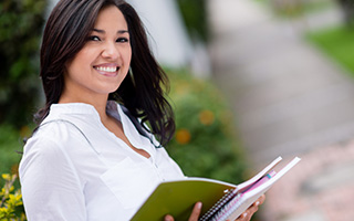 Young woman holding notebook outdoors