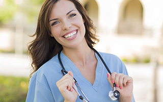 Nurse with stethoscope standing outdoors