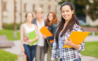 Happy students walking outside with clipboards