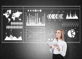Businesswoman with tablet analyzing various charts and data visualizations on a digital blackboard.