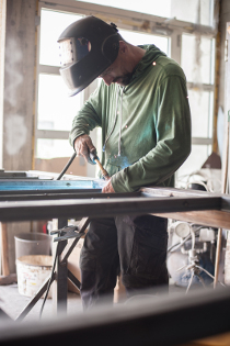 Welder on construction site welding small object