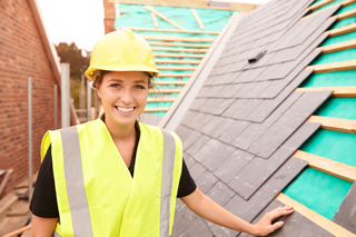 Female construction worker in safety vest and helmet at a residential roofing site